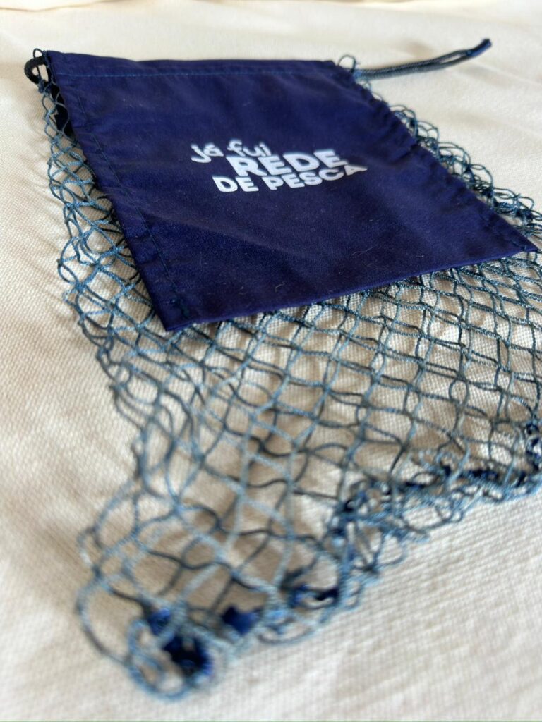Redeco de rede de pesca reaproveitada com bolso de tecido azul estampado com a frase já fui rede de pesca